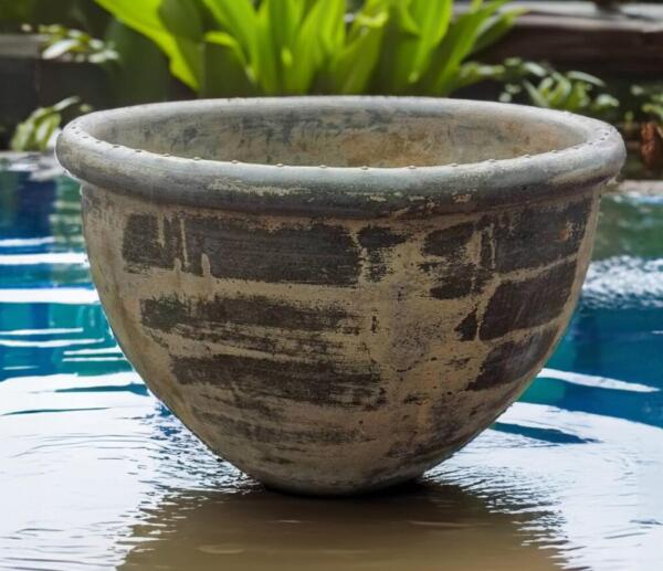 Crafted by hand from premium Thai limestone, this rustic pot features a textured, sandstone finish in a natural yellow-green hue—perfect for creating a lush, tropical feel in any space. Its raw, chiseled rim gives it a bold, sculptural look, making it ideal for both residential gardens and commercial landscaping projects.